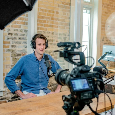 Person being interviewed behind camera in blue shirt