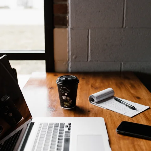 Laptop, notebook and coffee on table