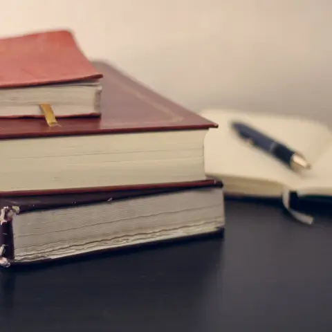 Stack of old legal books and a classic pen