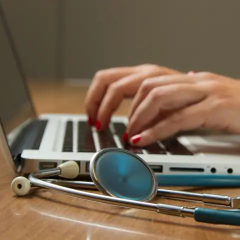 A doctor working behind a laptop