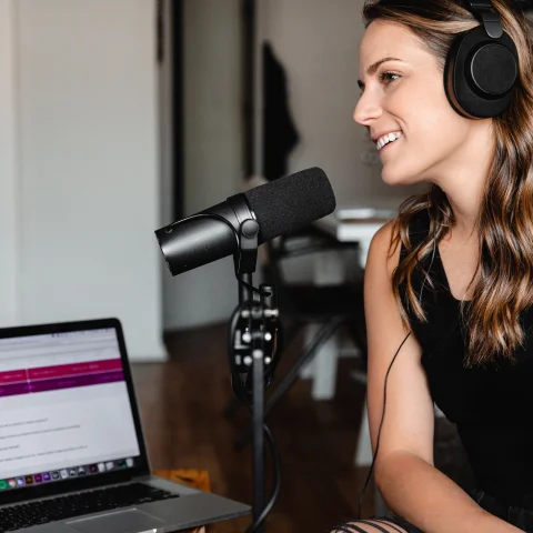 A podcaster recording behind laptop and professional microphone